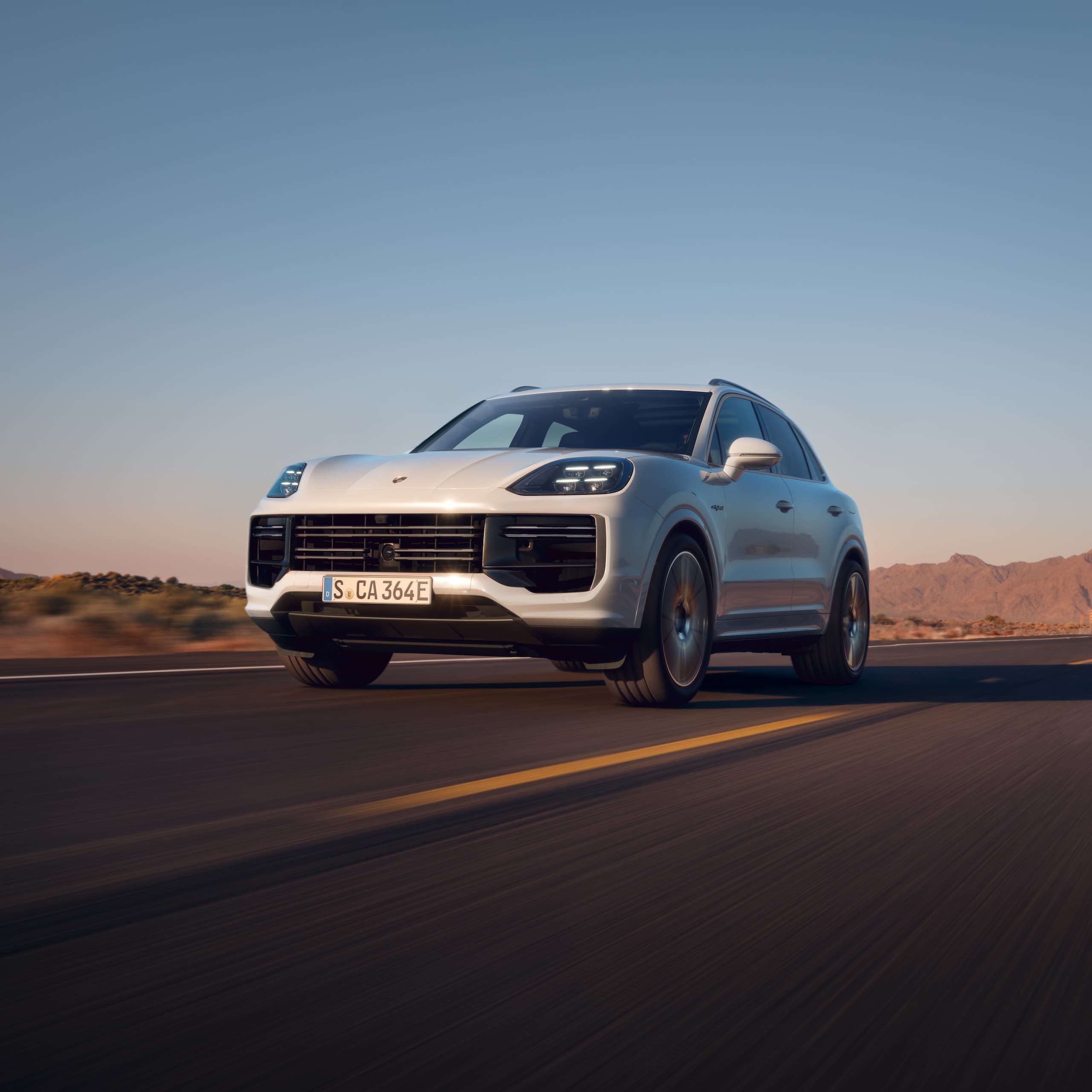 Una Porsche Cayenne che guida su una strada aperta.