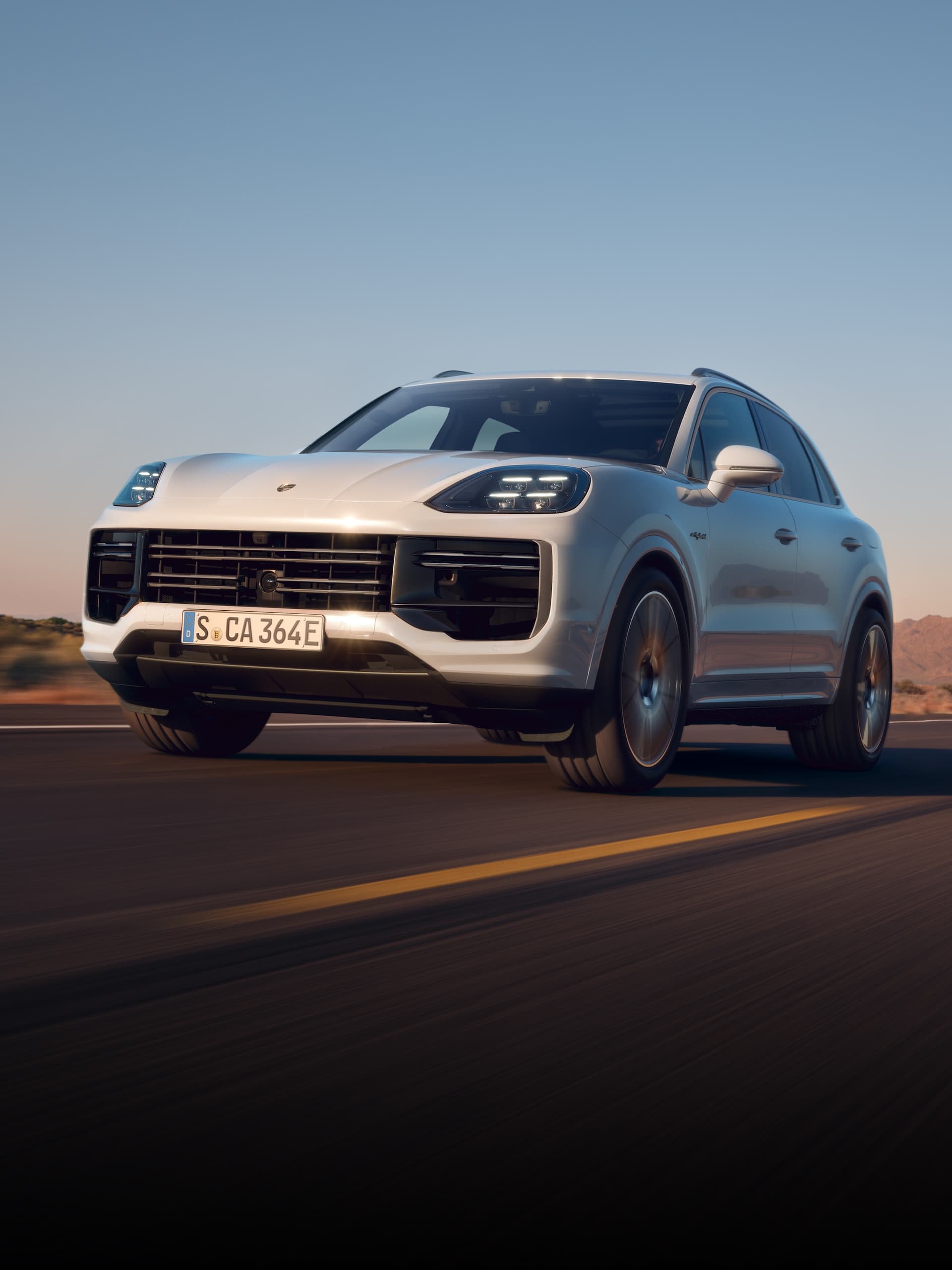 Una Porsche Cayenne che guida su una strada aperta.
