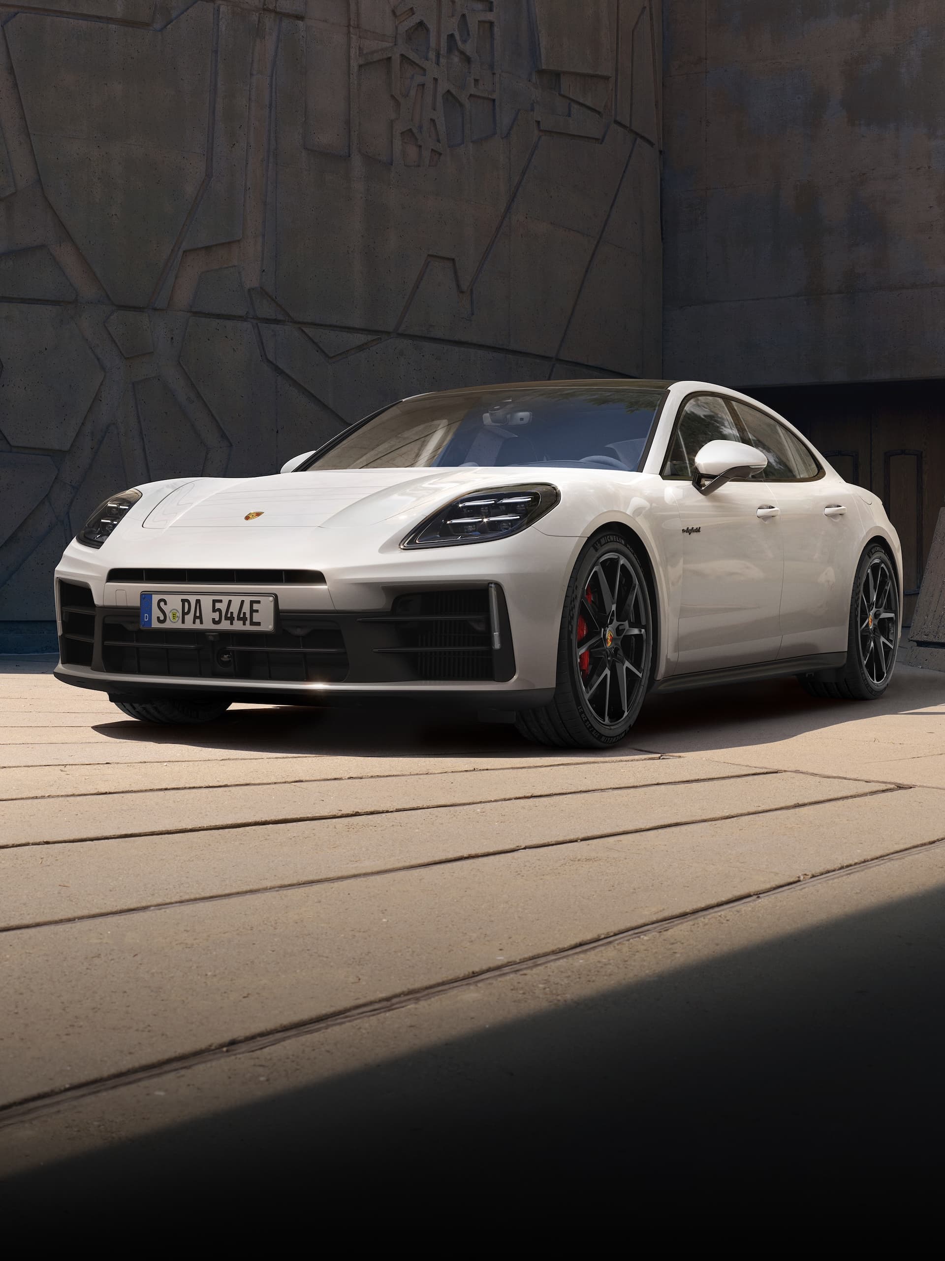 Una Porsche Panamera parcheggiata davanti a un edificio moderno.